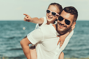 Father and sun enjoying the beach after an eye exam